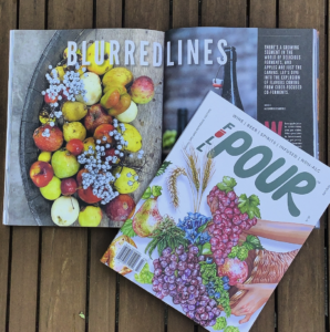 two full pour magazines on a wooden table. one with the cover displayed and the other showing the article